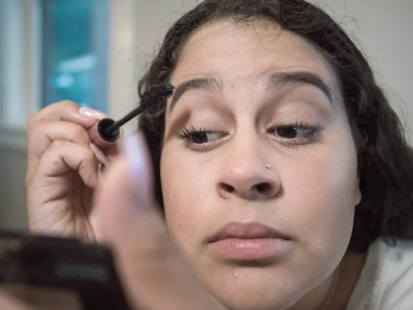 A client filling in her brows at the mirror, the daily upkeep a good shape removes